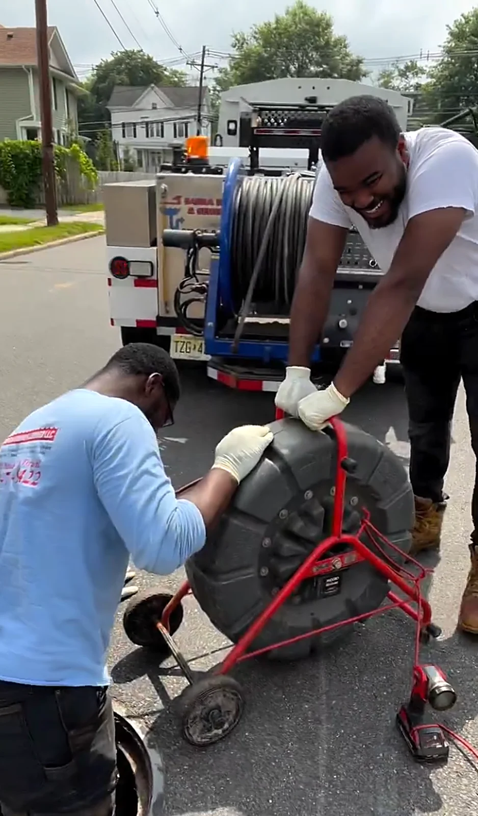 Technicians with drain cleaning machine and hydro-jetter trailer