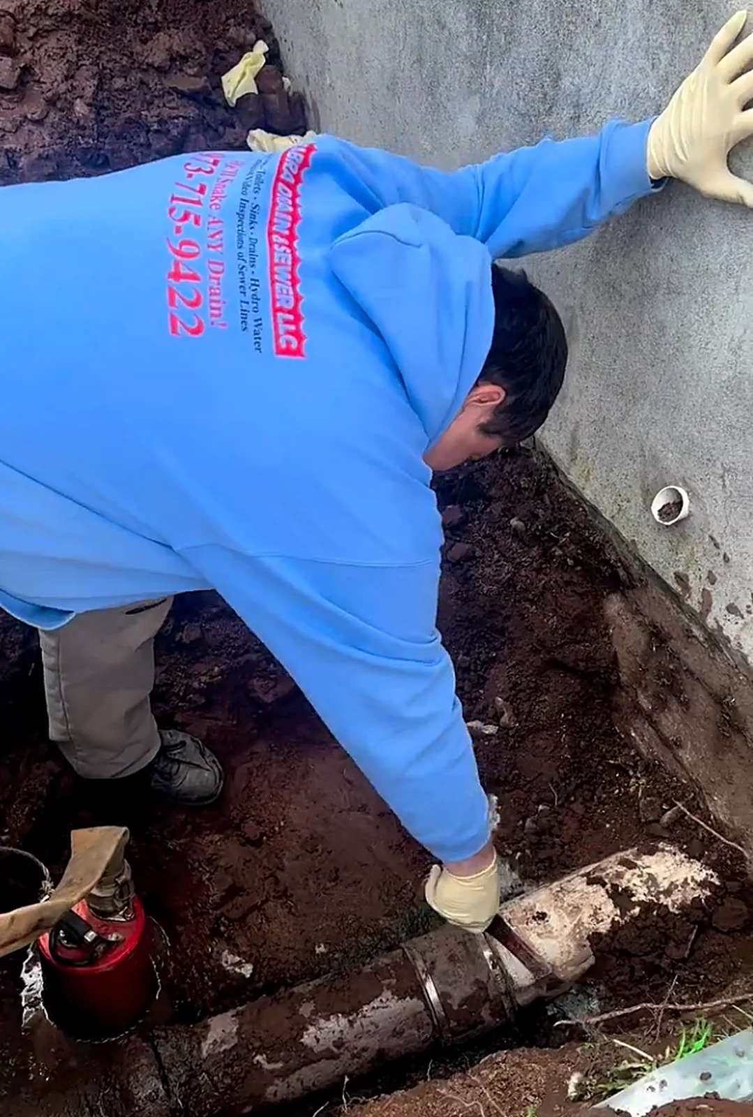 Technician repairing exposed sewer pipe
